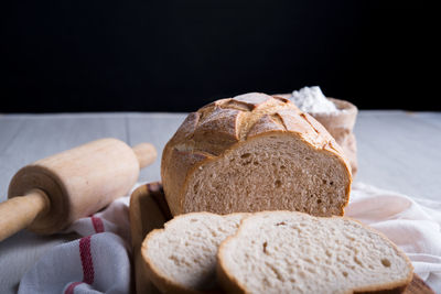 Close-up of bread on table against black background