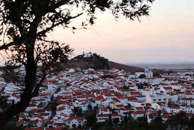 Aerial view of townscape by sea during sunset