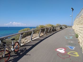 Road by sea against blue sky