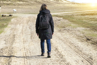 Rear view of woman walking on road