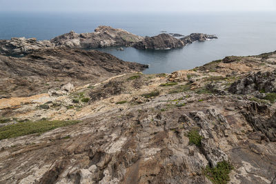 Scenic view of sea by cliff against sky