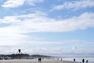 People on beach against sky