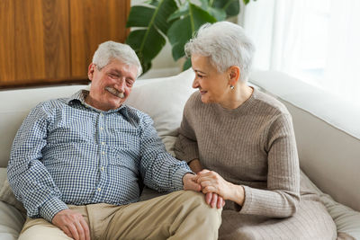 Portrait of senior couple sitting on sofa at home