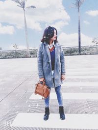 Full length of woman standing on snowy field against sky