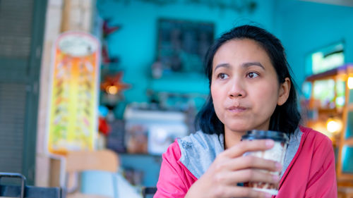 Portrait of young woman drinking water