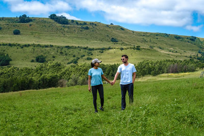 Couple holding hands walking on grass