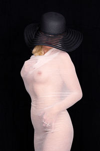 Rear view of woman standing against black background