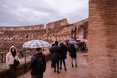 Rear view of people in front of historical building