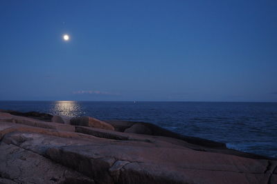 Scenic view of sea against clear sky at midnight.