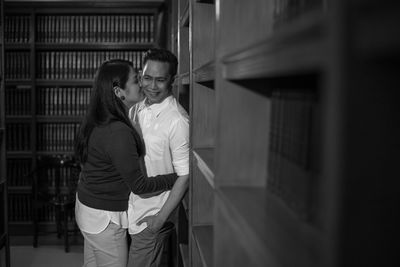 Young man and woman standing against wall