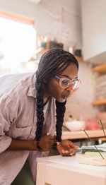 Woman with braided hair lighting up incense