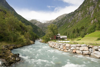 Scenic view of river amidst mountains against sky