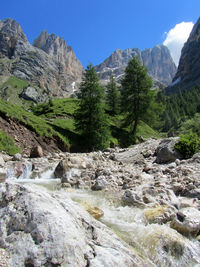 Scenic view of river by mountains against sky