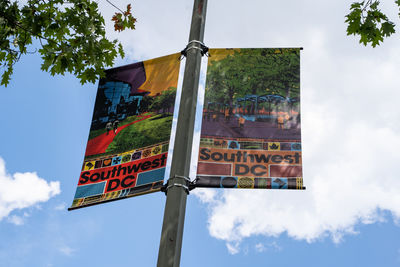 Low angle view of flags sign against sky