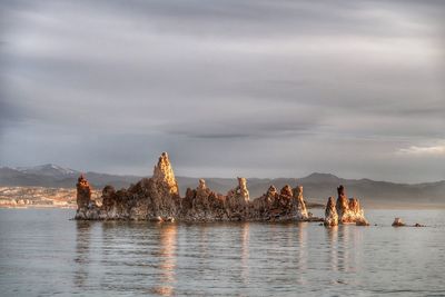 Landscape of tufa formations surrounded by water and mountains at mono lake in california 