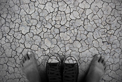 Low section of man with shoes on ground