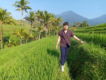 Rear view of woman walking on field