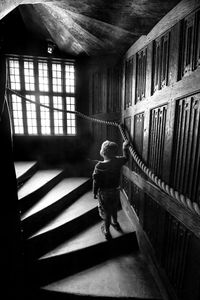 Rear view of man walking on staircase