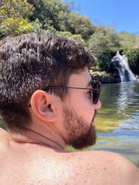 Portrait of beardy shirtless man in a waterfall