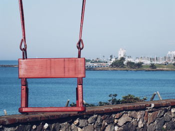 Close-up of bollard against sea against clear sky