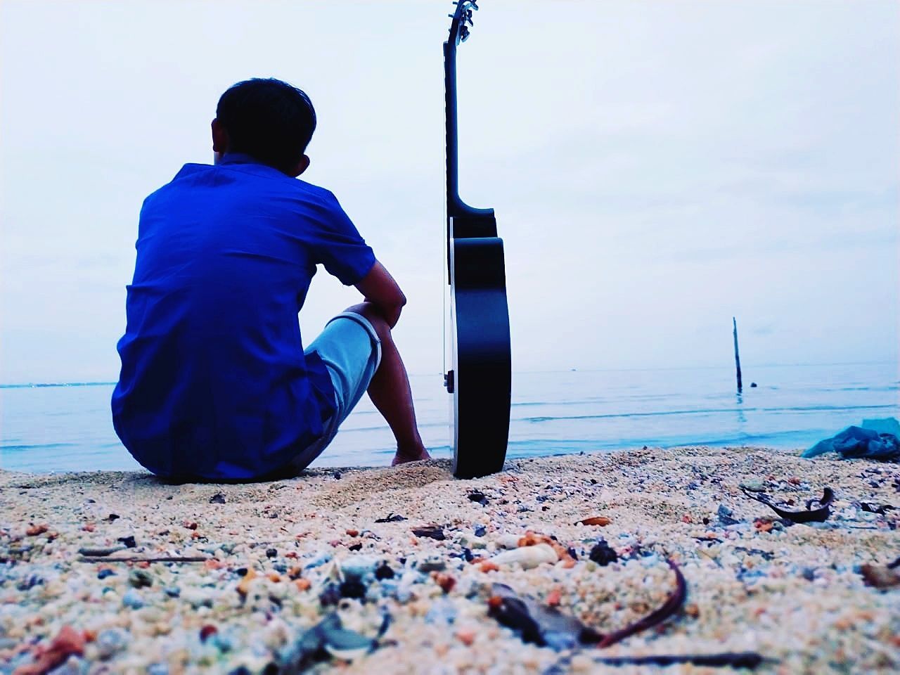 real people, sea, water, men, rear view, beach, land, one person, sky, day, lifestyles, leisure activity, nature, sitting, blue, horizon over water, horizon, full length, outdoors, pebble