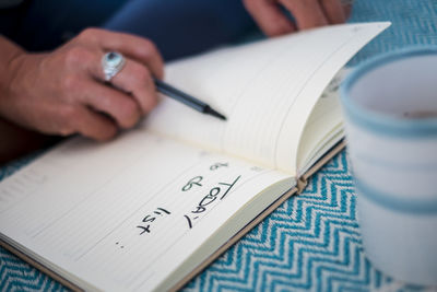 Midsection of person reading book on table