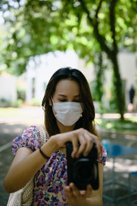 Young woman wear surgical protection mask use camera , travel , inspiration and recreation concept
