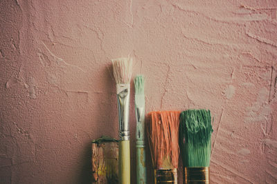 Close-up of paintbrushes against wall