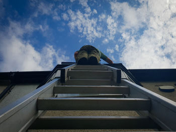 Low angle view of man on staircase against sky