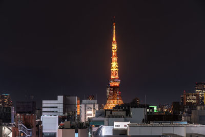 Illuminated buildings against sky at night