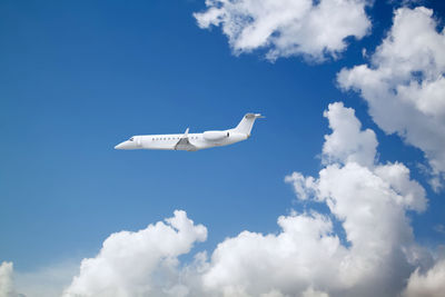 Low angle view of airplane flying against sky