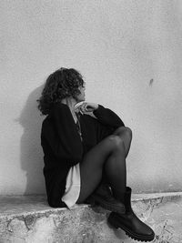 Side view of woman sitting on floor