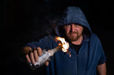 Midsection of man holding sparkler at night