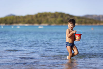 Shirtless man swimming in sea