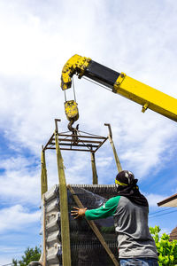 Low angle view of crane against sky