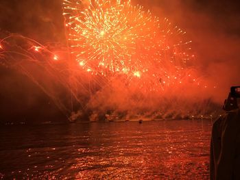 View of firework display over river at night