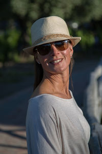 Young woman wearing sunglasses and sun hat