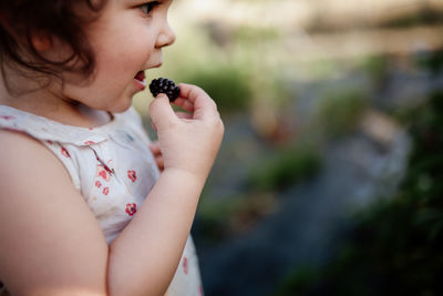 Little girl eating blackberries