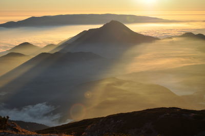 Idyllic shot of mountains in foggy weather during sunrise