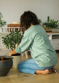 Rear view of woman sitting on chair at home