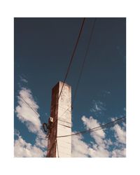 Low angle view of wooden post against sky