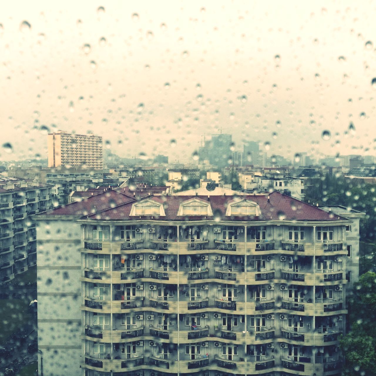 building exterior, architecture, built structure, window, city, cityscape, drop, water, transparent, sky, glass - material, wet, residential structure, residential building, rain, indoors, weather, residential district, day, no people