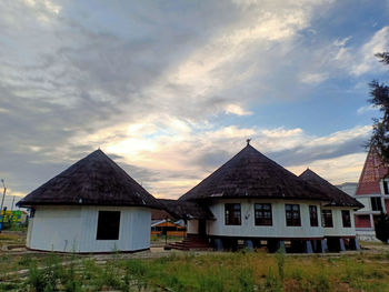 House on field against sky during sunset