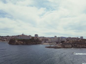 Buildings in city against cloudy sky