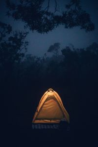 Low angle view of illuminated tent against sky at night