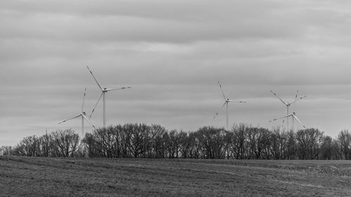 Traditional windmill on field against sky