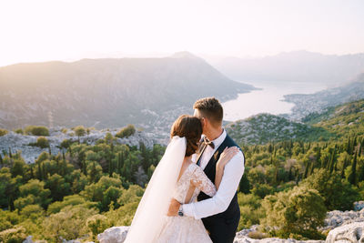 Couple standing on mountain against mountains
