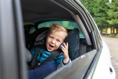 Portrait of boy looking through car window