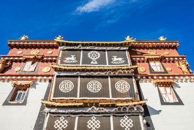 Low angle view of text on building against sky