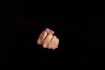 Close-up of hand against black background